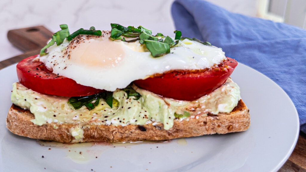 whipped cottage cheese toast, close up on a white plate with a blue napkin