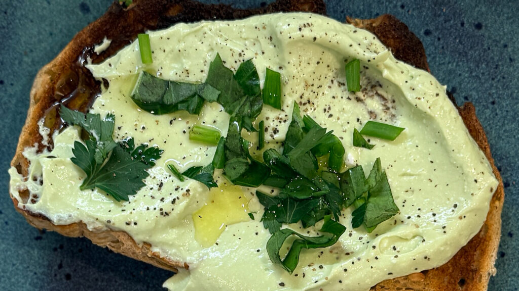 whipped cottage cheese toast with fresh herbs before being finished