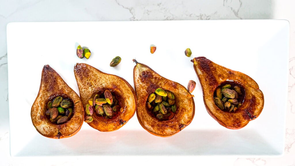 Maple Olive Oil Bosc Pears, cooked Bosc Pears with Piscachios sprinkled around.
