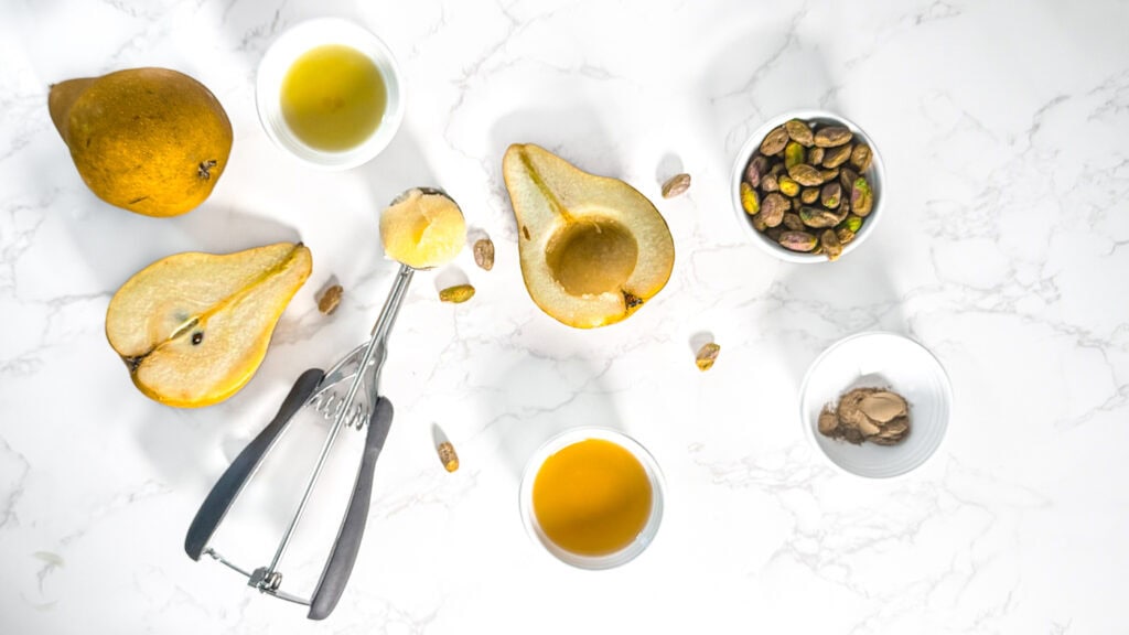 Maple Olive Oil Bosc Pears ingredients flatly with two bosc pears, a Mellon baller, maple syrup, cinnamon, pecans, olive oil