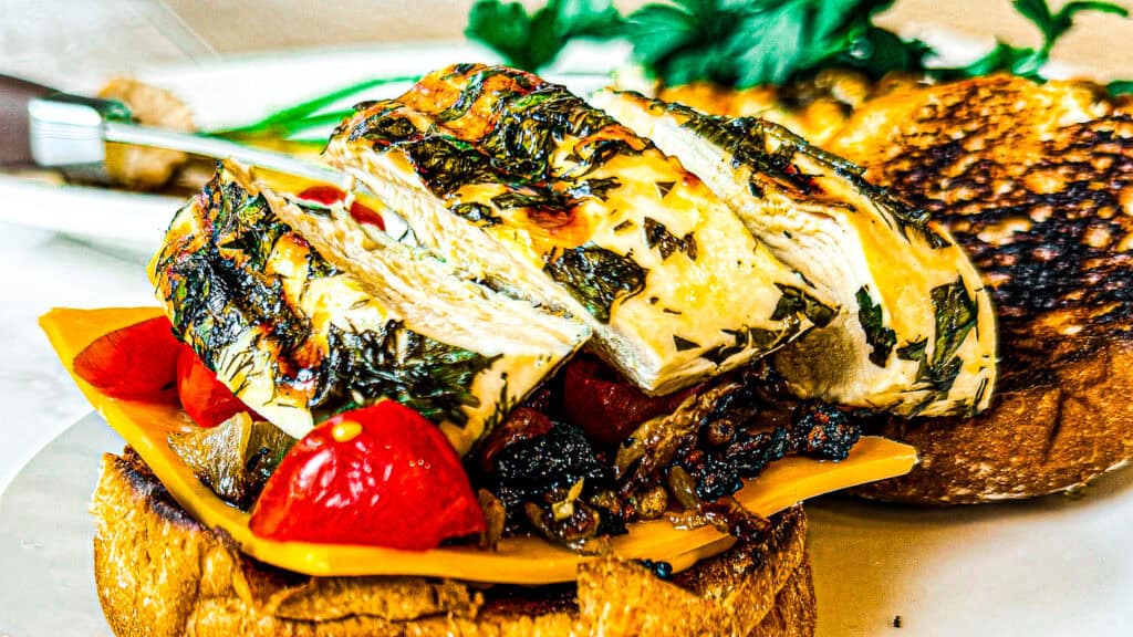 Juicy grilled lemon herb chicken served with fresh vegetables and bread.