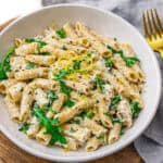lemon ricotta protein pasta in a white bowl with a gold fork and a blue linen napkin