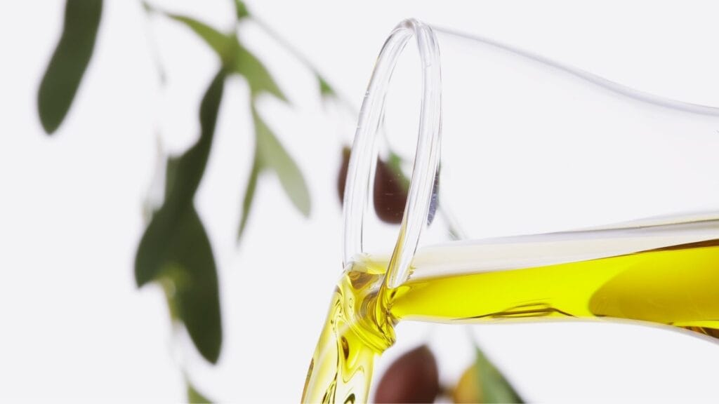 Mediterranean diet for GLP-1 Nausea, olive oil being poured, olive branch in the background