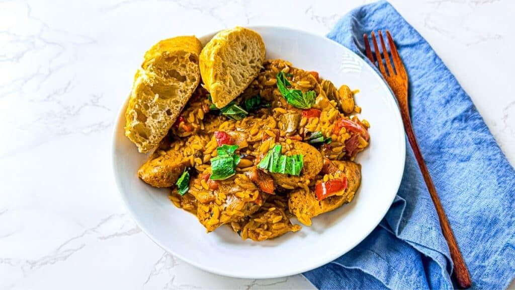 A flavorful dish featuring Braised Chicken Sausages with Peppers topped with herbs, perfect for a comforting and satisfying meal.