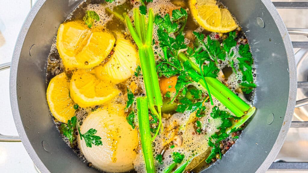 celery, lemons, onion, chicken bones, chicken skin, and water boiling