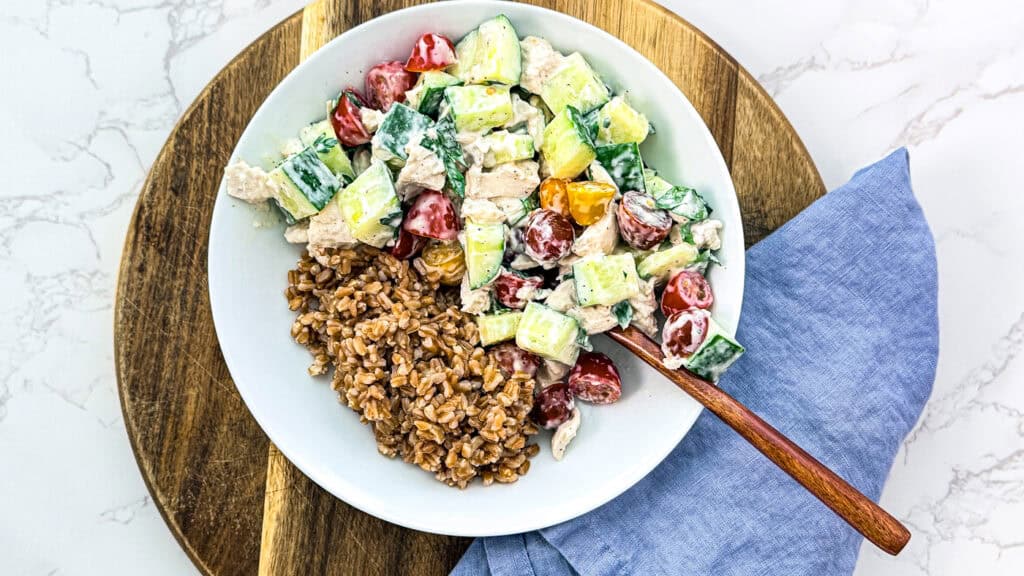 on a cutting board, with a blue linen napkin and a wooden fork