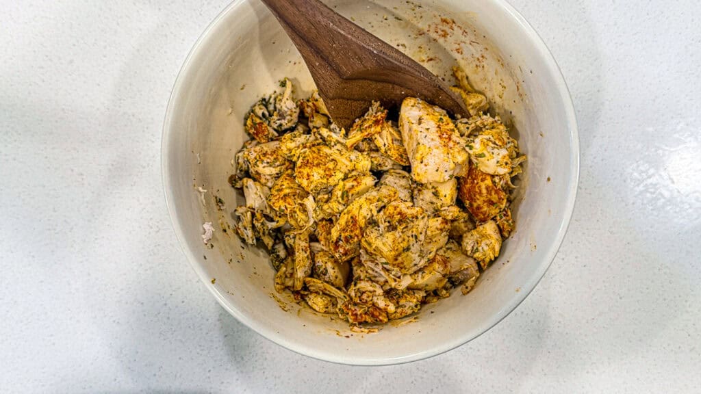 Chicken salad with herbs in a white bowl, perfect for healthy meals and lunch.