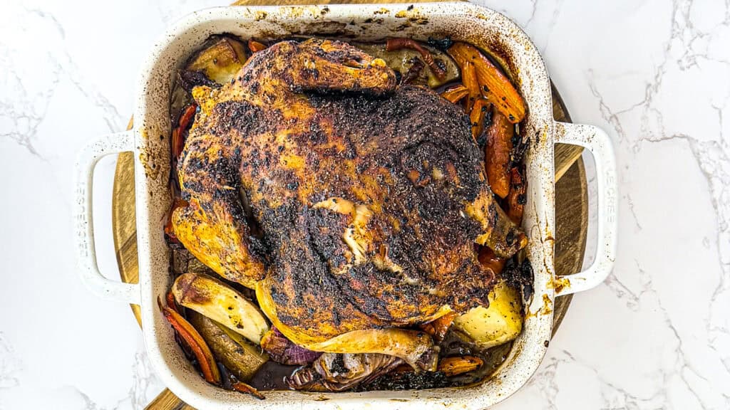 chicken roasted in a dish over root vegetables.