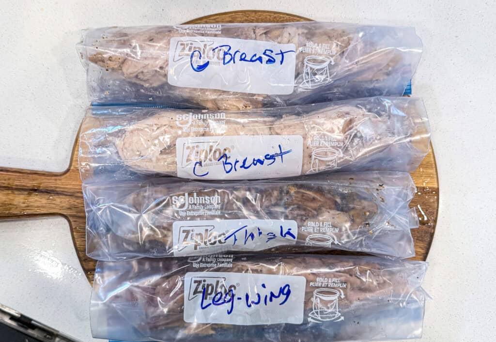 Easy Sumac Roasted Whole Chicken chicken breast, thighs, legs and wings in freezer safe bags on a cutting board
