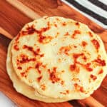 Potato flatbread, homemade, golden-brown, served on a wooden board.