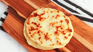 Potato flatbread, homemade, golden-brown, served on a wooden board.