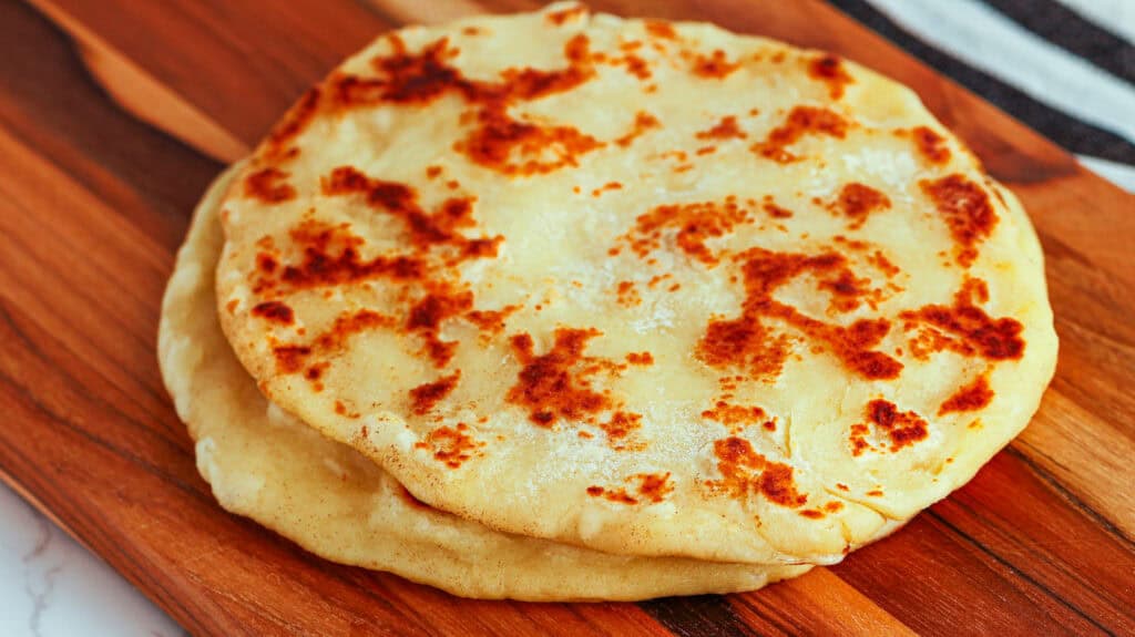 Naan bread served hot, perfect for pairing with Indian dishes at The Lemon Hearth.