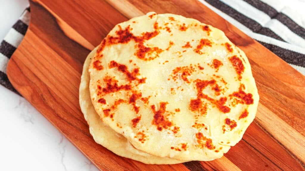 Close-up of homemade Greek yogurt flatbread on wooden board.