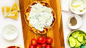 Delicious homemade Greek tzatziki served on flatbread, garnished with fresh tomatoes and accompanied.
