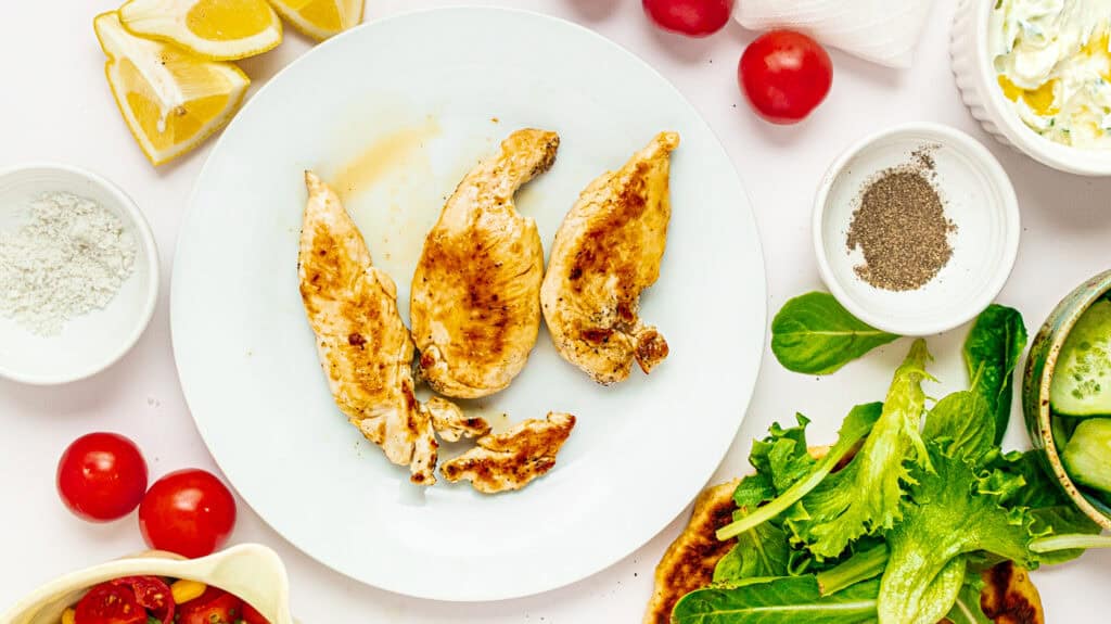 High‑Protein Mediterranean Chicken Flatbread Bowl Grilled chicken wings with fresh vegetables and herbs, perfect for healthy meals.