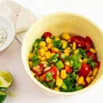 Healthy corn and cherry tomato salad with fresh cilantro in a rustic bowl.