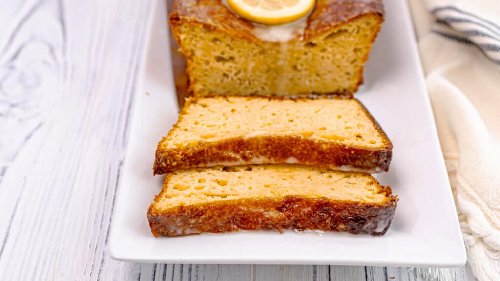 Slices of lemon orange olive oil loaf cake on a white plate.