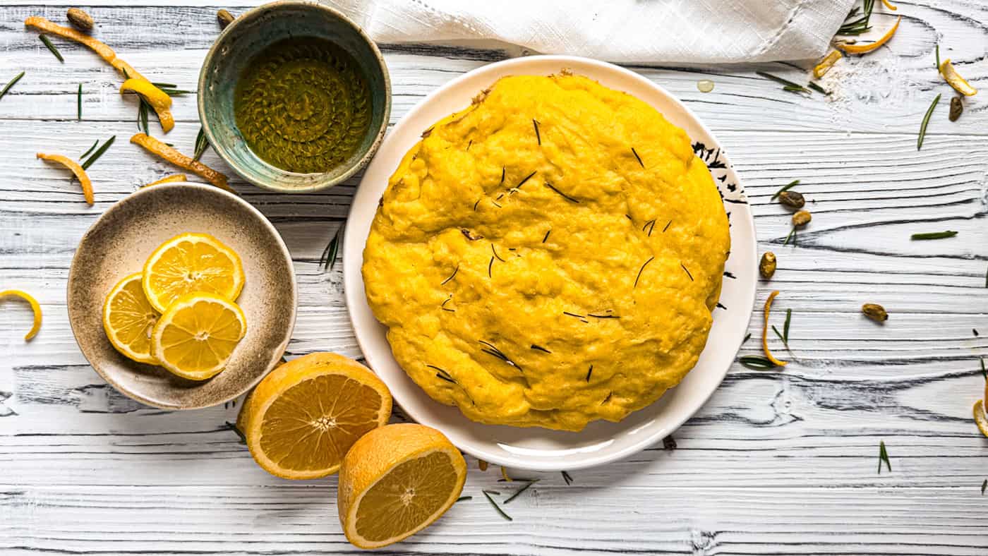 Olive oil cake with lemon and orange slices on a rustic board