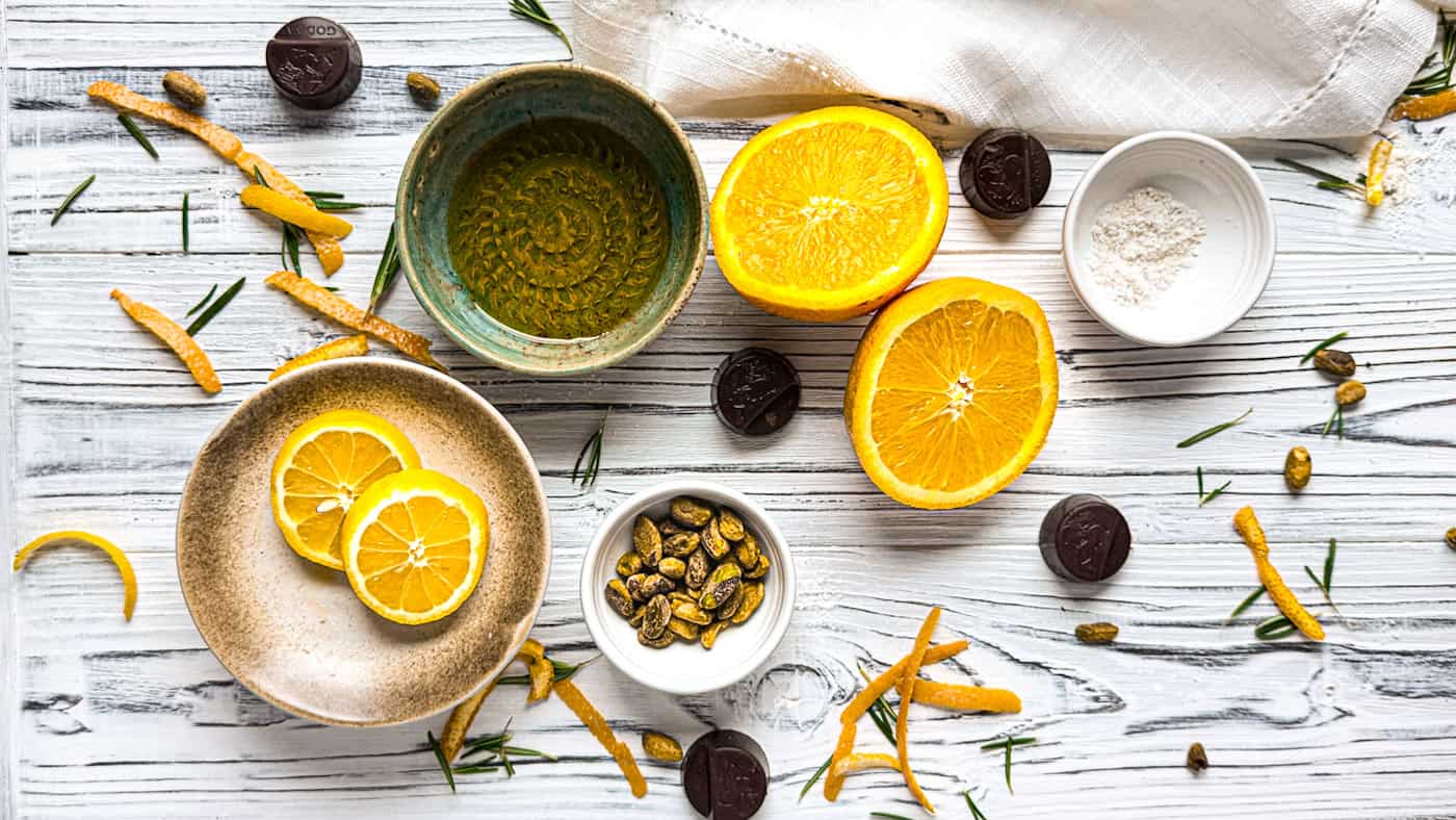 Fresh lemons, olive oil, and baking ingredients on a rustic white table.
