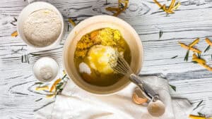 A ceramic bowl with olive oil cake ingredients