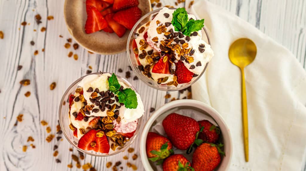Delicious vanilla and strawberry parfait with rose petals and chocolate chips.