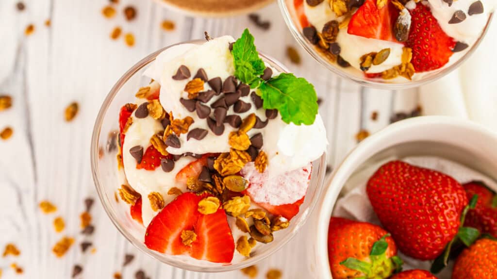 Delicious vanilla and strawberry parfait with rose petals and chocolate chips.