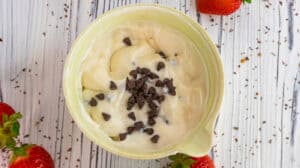 Creamy vanilla and strawberry parfait with chocolate chips in a bowl.