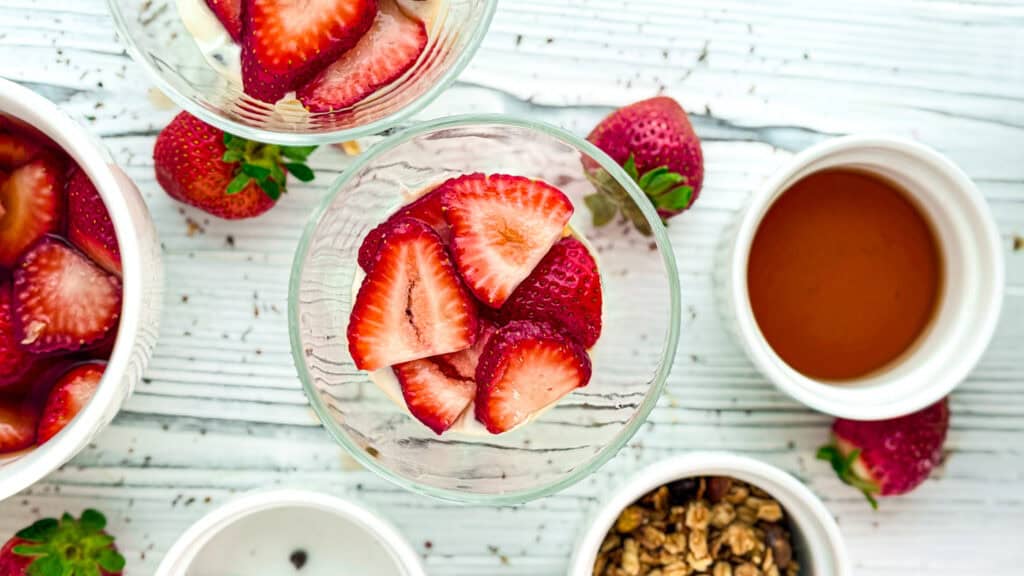 Delicious strawberry parfait topped with fresh strawberries and rose petals.