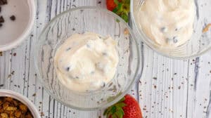 Creamy vanilla and strawberry parfait with rose flavor in glass bowls.