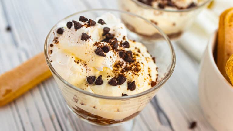 Creamy tiramisu yogurt cups topped with chocolate chips and cocoa powder.