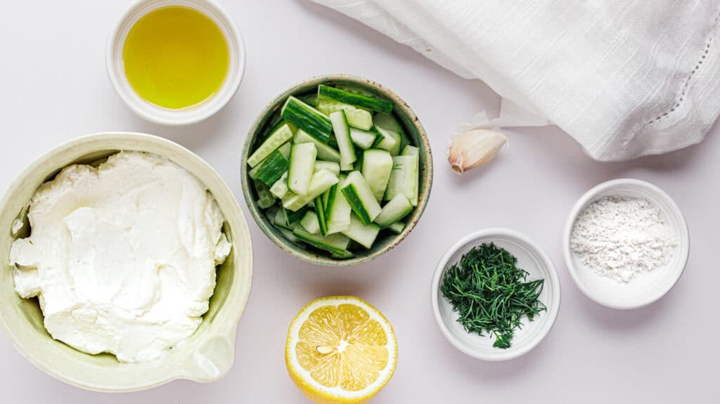 High-Protein Greek Yogurt Tzatziki Dip with Fresh cucumber, herbs, lemon, and dairy ingredients for healthy cooking.