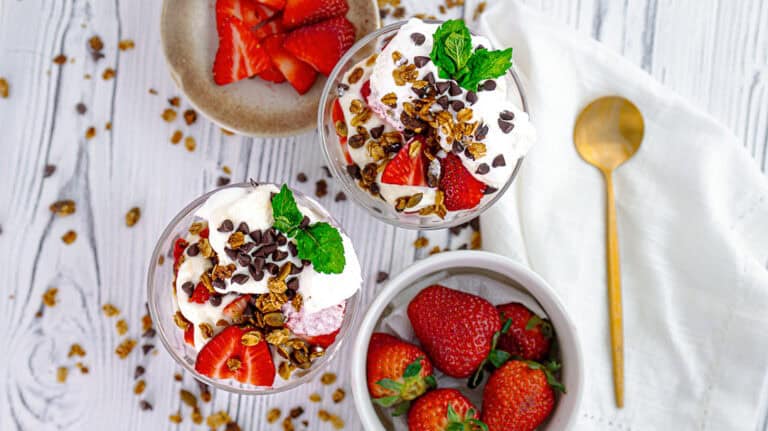 two vanilla-strawberry rose parfait on a wooden board