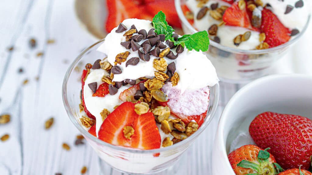 Delicious vanilla and strawberry parfait with rose petals and chocolate chips.