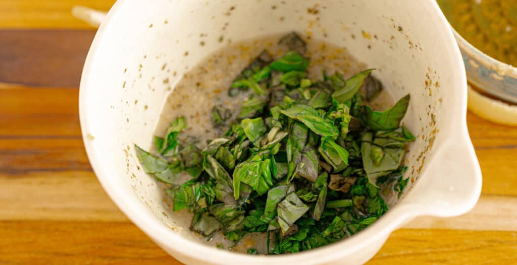 dressing ingredients with fresh herbs in a bowl