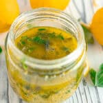 lemon-orange herb dressing surrounded by lemons and basil